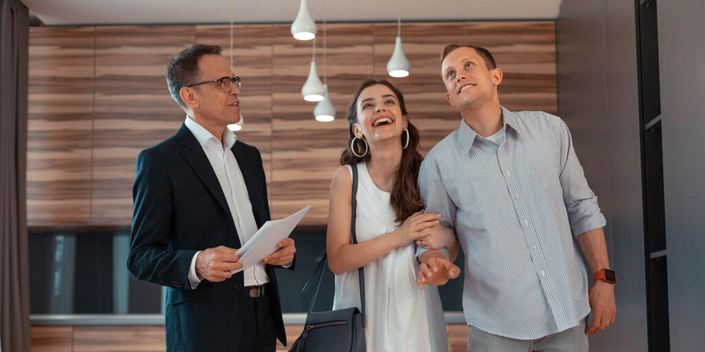 Buying new apartment. Wife feeling amazing while buying new apartment with husband while standing near realtor